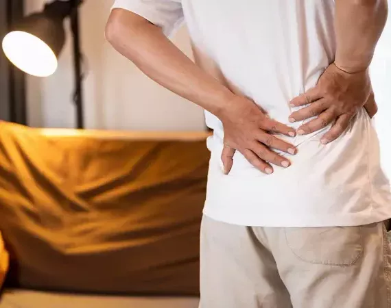 Mann hält sich den unteren Rücken - Rückenschmerzen.